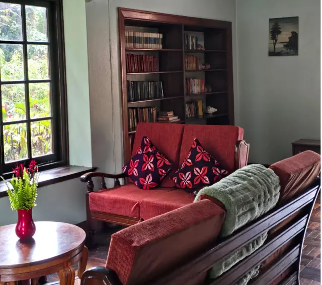 The library at Mullers — shelves of books, worn armchairs, a calm room for slow afternoons